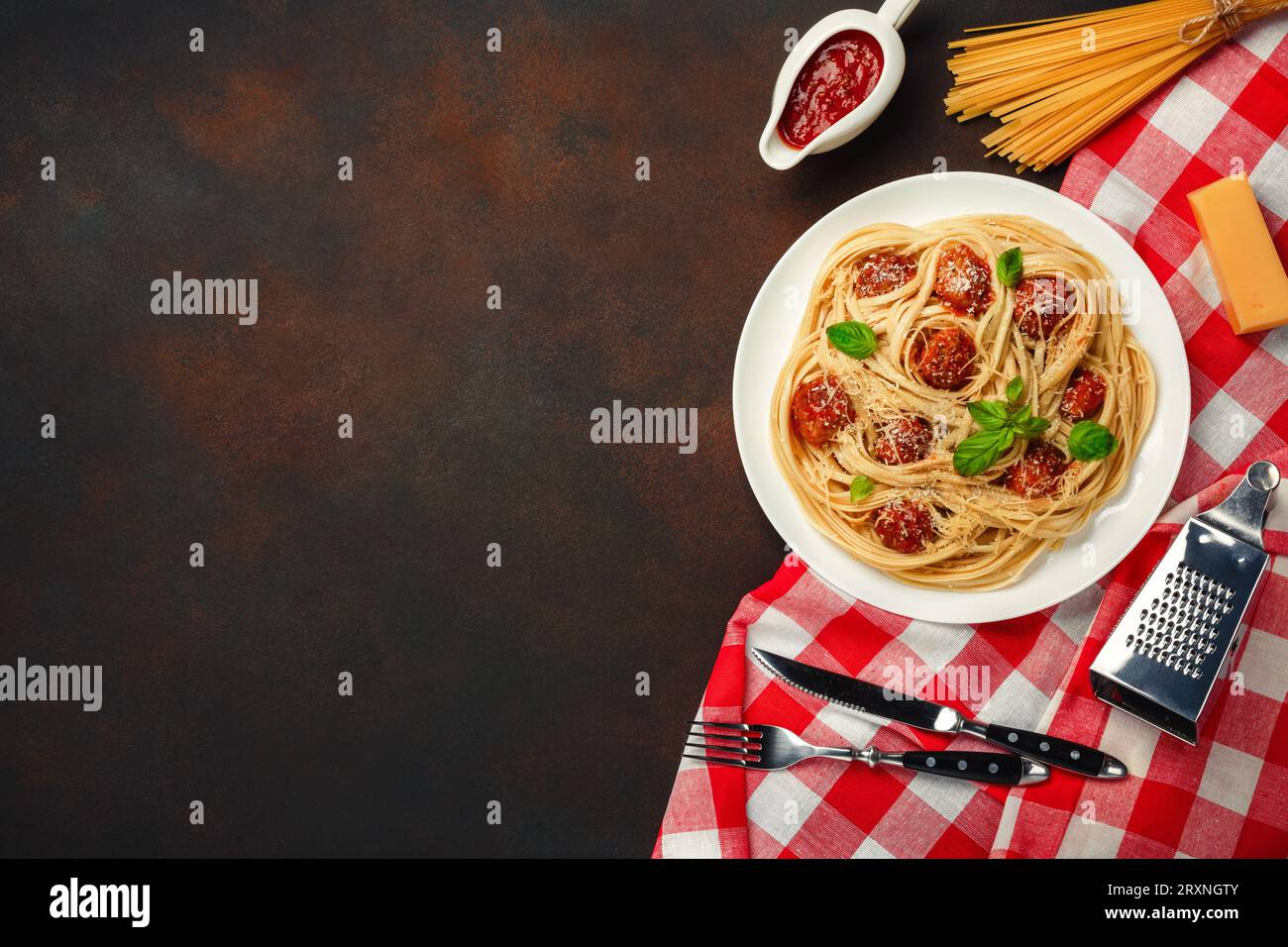 Spaghetti con polpette, salsa di pomodoro ciliegia su sfondo arrugginito, vista dall'alto. Foto Stock