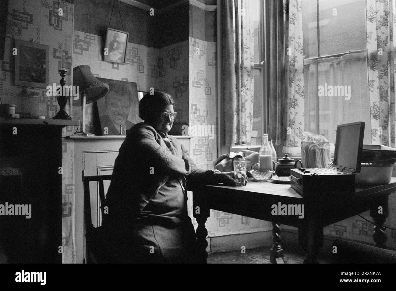 Anziana signora sedeva nella sala d'ingresso della sua casa vittoriana che è in attesa di demolizione durante la slum clearance di St Ann's, Nottingham, Inghilterra. Foto Stock