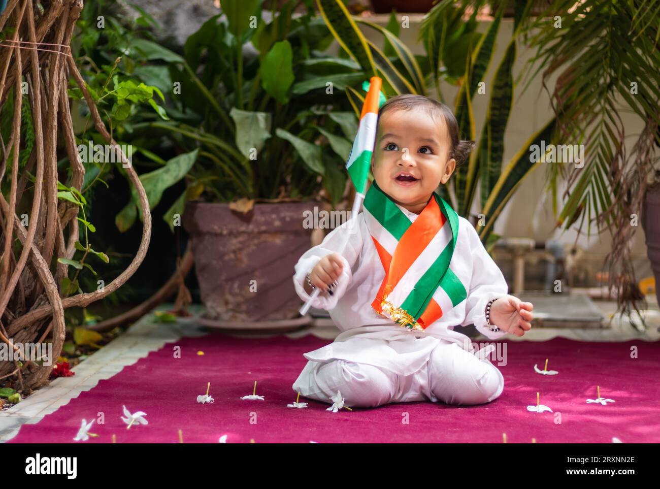 simpatico bimbo con bandiera tricolore indiana in un panno tradizionale con un'espressione facciale innocente Foto Stock