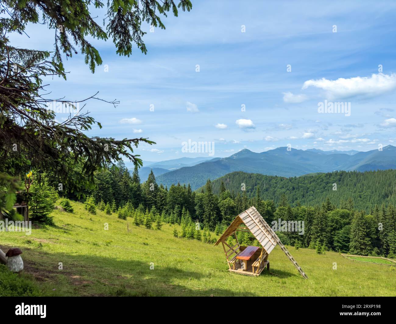 Splendido paesaggio di una valle di montagna con gazebo per il relax e vista sulle cime delle montagne Foto Stock