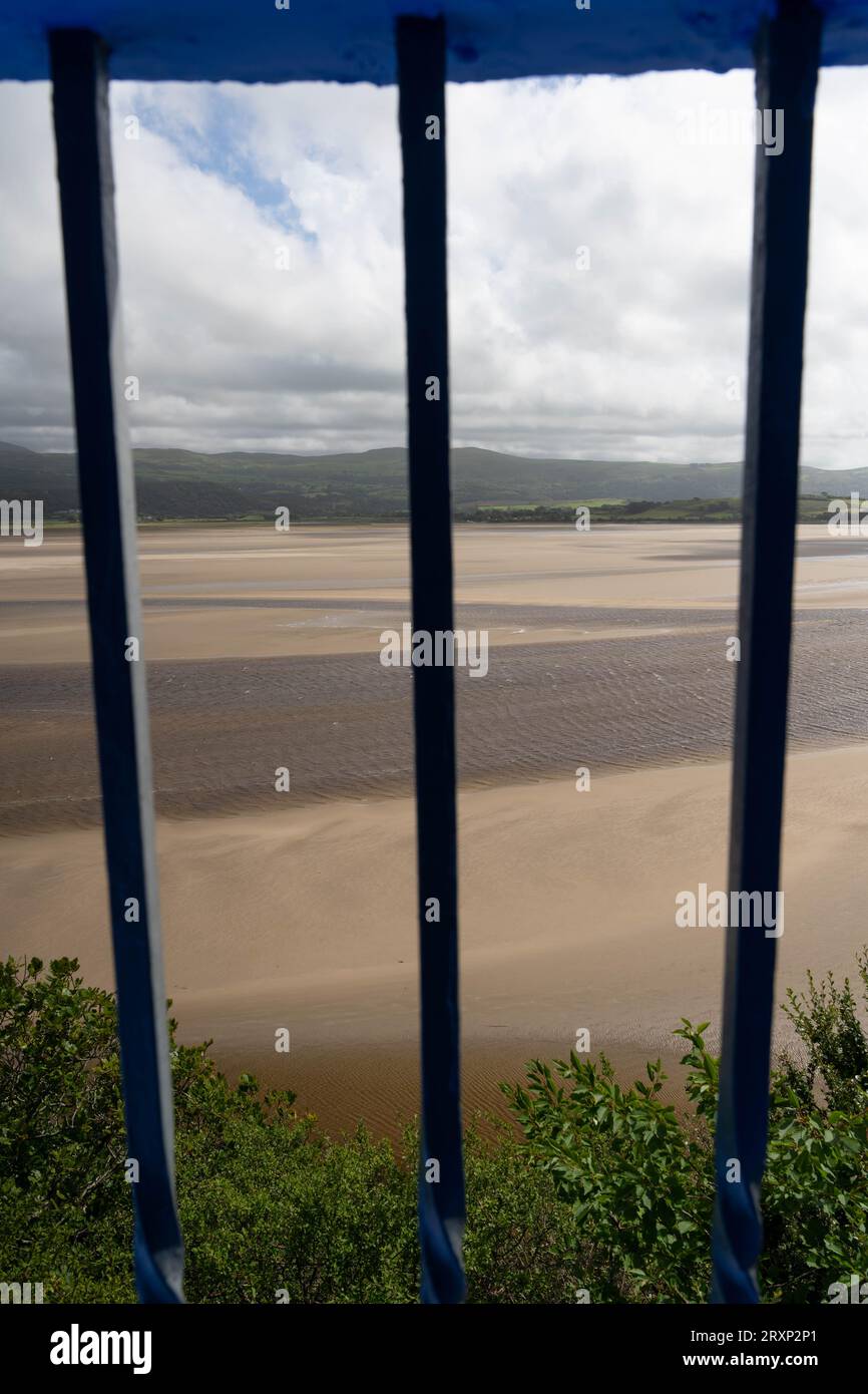 Vista dell'estuario di Portmeirion attraverso ringhiere blu con spiaggia sabbiosa e montagne gallesi Foto Stock