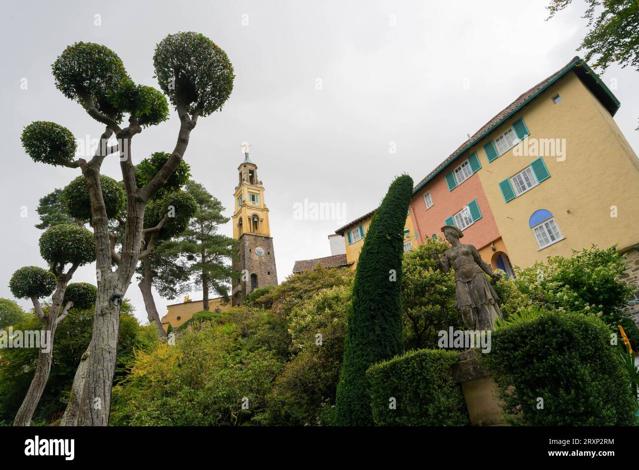 Colorati edifici italiani e campanile nel villaggio di Portmeirion con alberi topiari Foto Stock