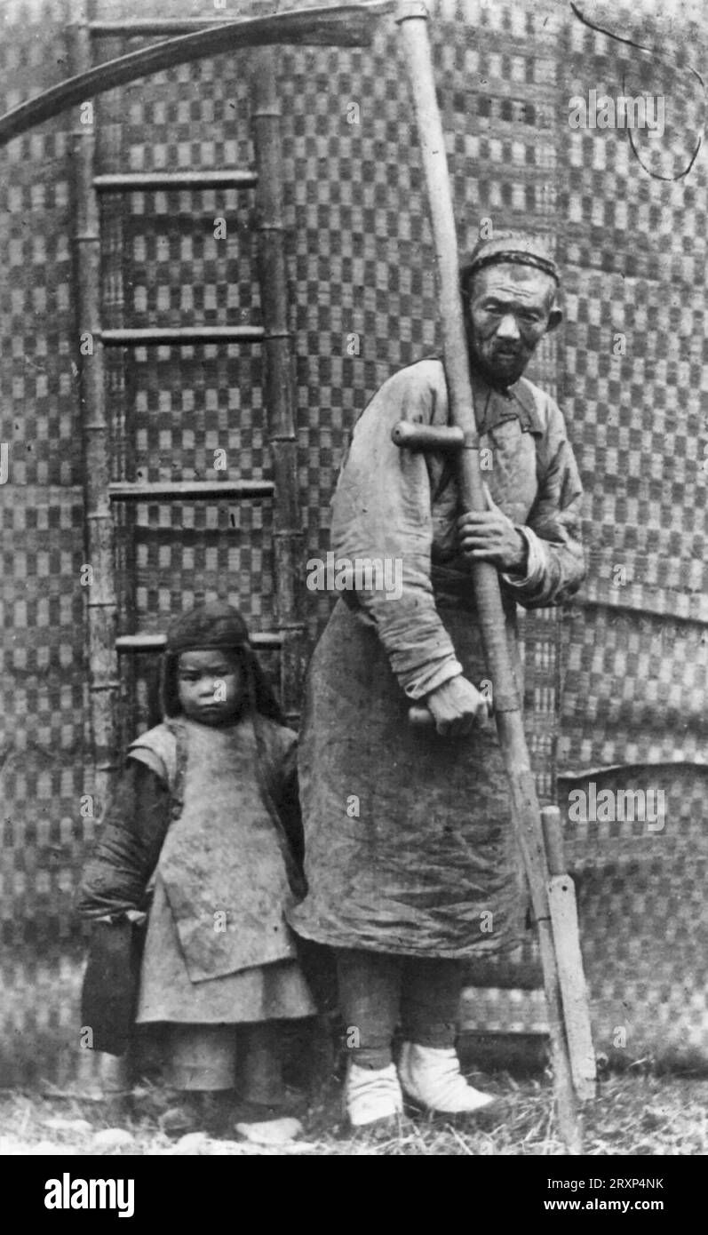 Operaio agricolo - la fotografia mostra un operaio agricolo cinese, ritratto a tutta lunghezza, in piedi, di fronte, con una grande falce con un bambino accanto a lui, intorno al 1870 Foto Stock
