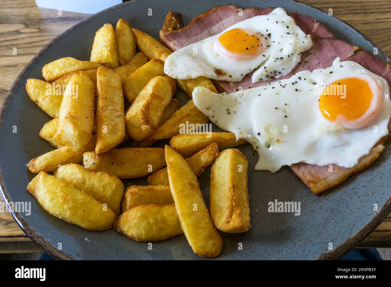 Un tipico pasto inglese da pub a base di prosciutto, uova e patatine fritte. Foto Stock