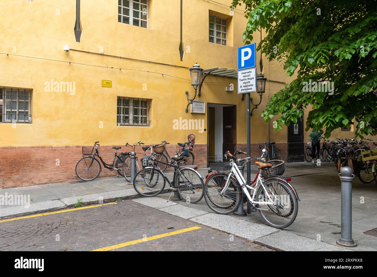 Biciclette parcheggiate fuori dall'ingresso del backstage del Teatro Regio, il teatro dell'opera di Parma, in estate, Emilia-Romagna, Italia Foto Stock