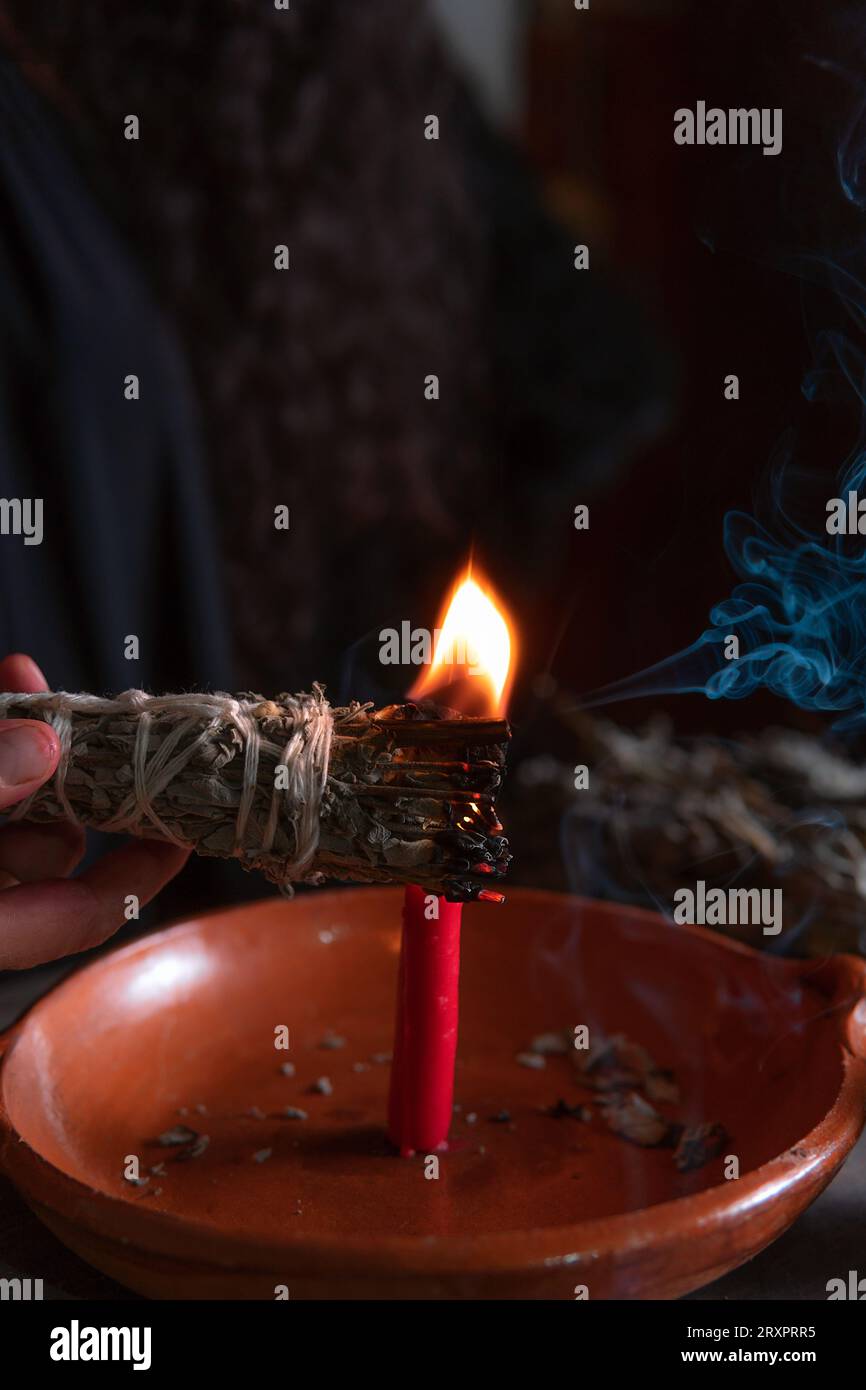 Accendendo un incenso, strega alla vigilia di tutti i santi che esegue un rituale di pulizia, Halloween, credenze spirituali, magia bianca Foto Stock