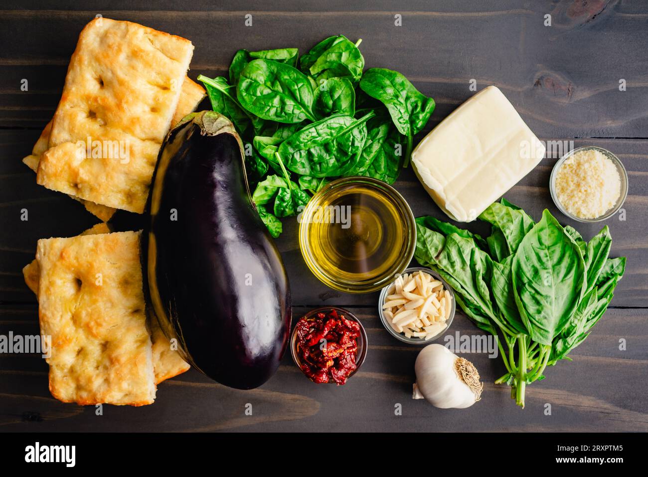 Ingredienti del sandwich Veggie tostato italiano su un tavolo di legno: Melanzane fresche, basilico, focaccia e altri ingredienti mediterranei Foto Stock