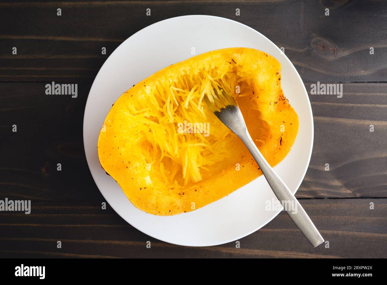 Tritare uno Spaghetti squash con una forchetta: Seminare e cucinare metà della zucca spaghetti tagliata con una forchetta Foto Stock