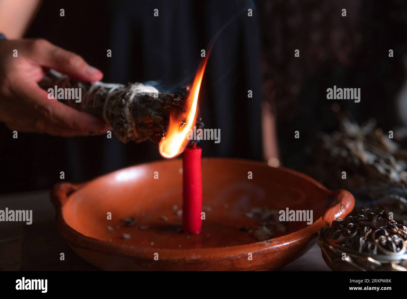 Accendendo un incenso, strega alla vigilia di tutti i santi che esegue un rituale di pulizia, Halloween, credenze spirituali, magia bianca Foto Stock