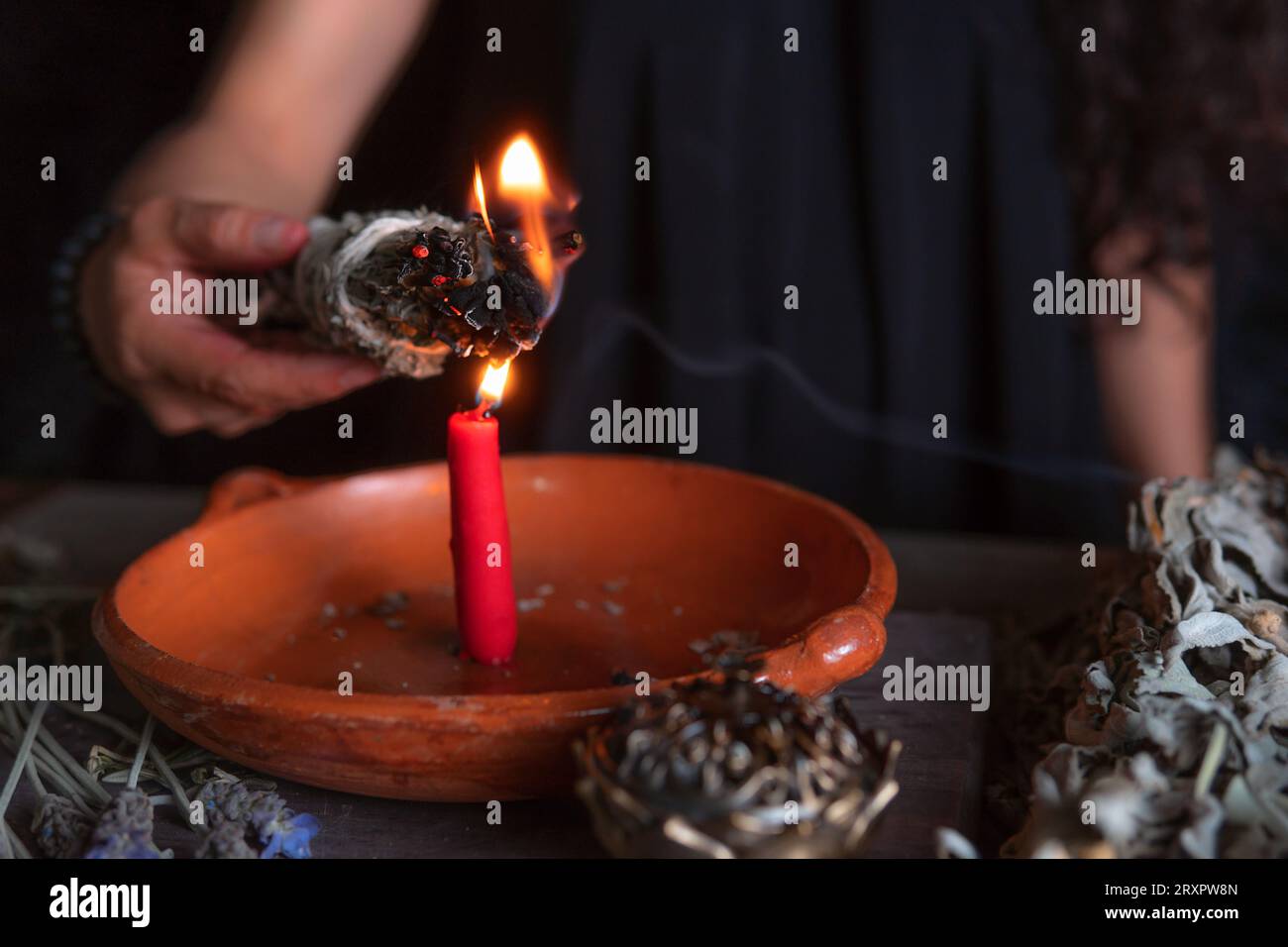 Accendendo un incenso, strega alla vigilia di tutti i santi che esegue un rituale di pulizia, Halloween, credenze spirituali, magia bianca Foto Stock