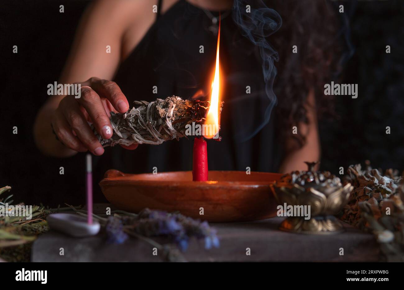 Accendendo un incenso, strega alla vigilia di tutti i santi che esegue un rituale di pulizia, Halloween, credenze spirituali, magia bianca Foto Stock