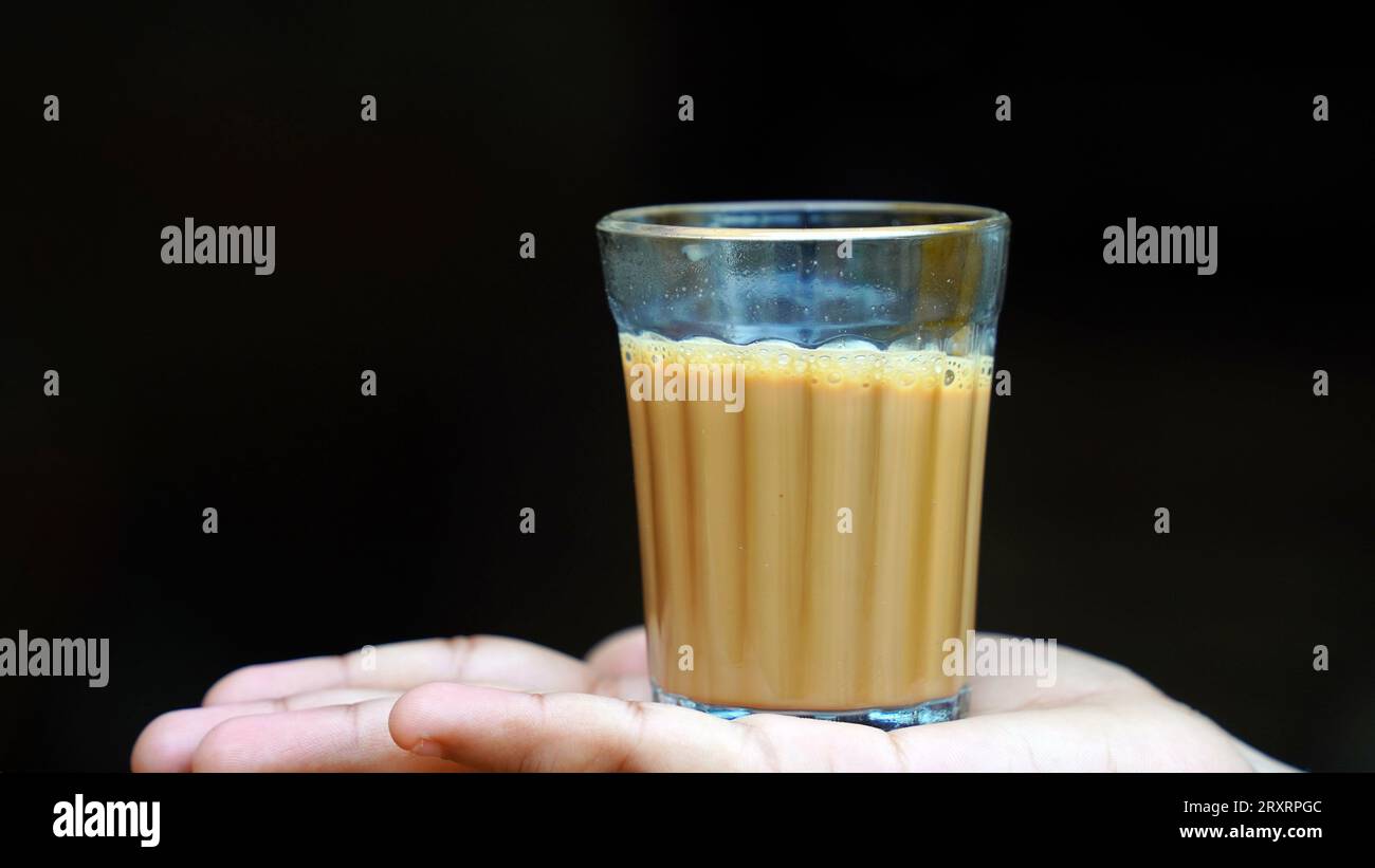Tè di masala indiano o chai in vetro tradizionale, sfondo di legno. caffè, retrò, ristorante, hotel. Il chai di taglio di prima mattina Foto Stock