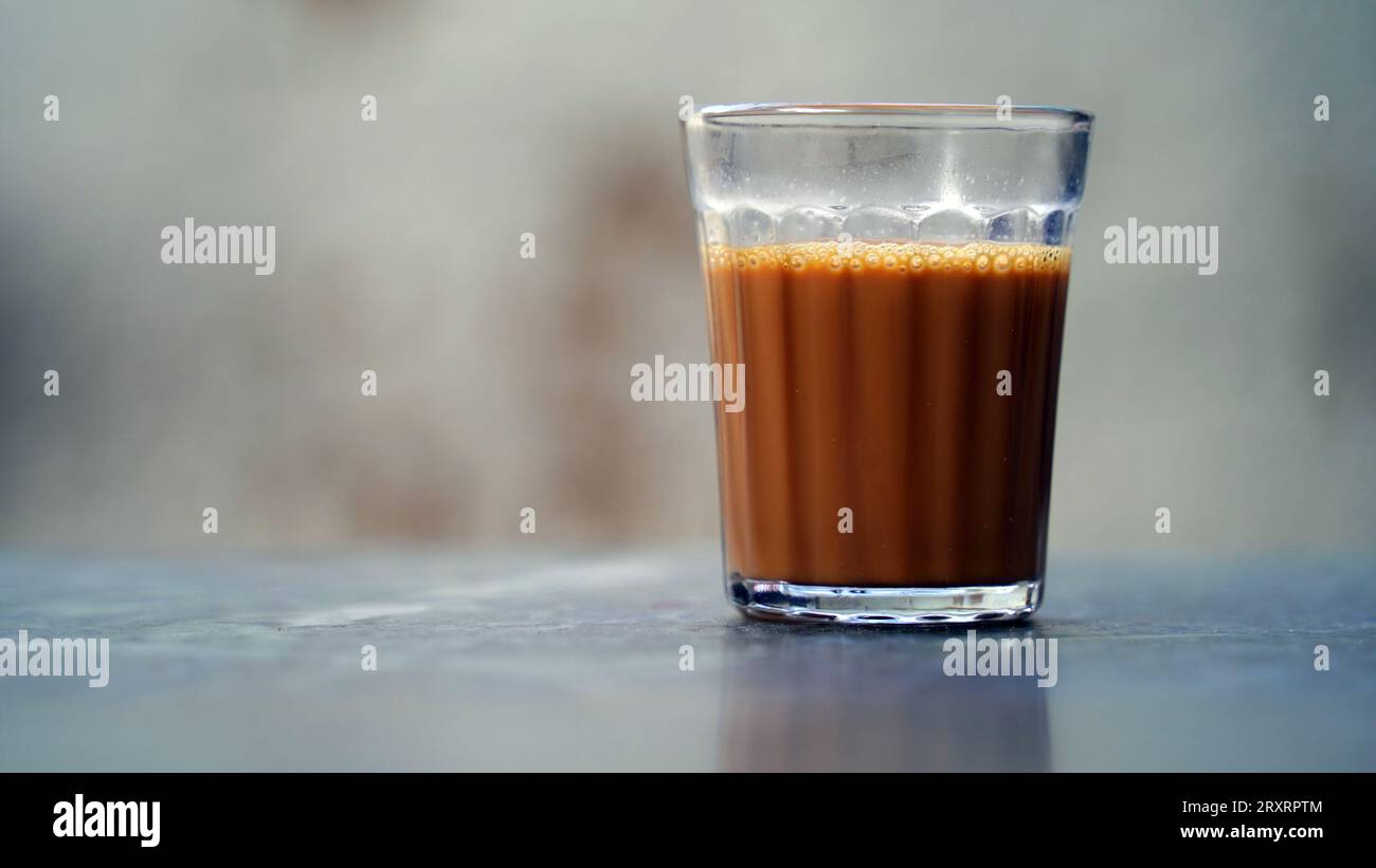 Tè di masala indiano o chai in vetro tradizionale, sfondo di legno. caffè, retrò, ristorante, hotel. Il chai di taglio di prima mattina Foto Stock