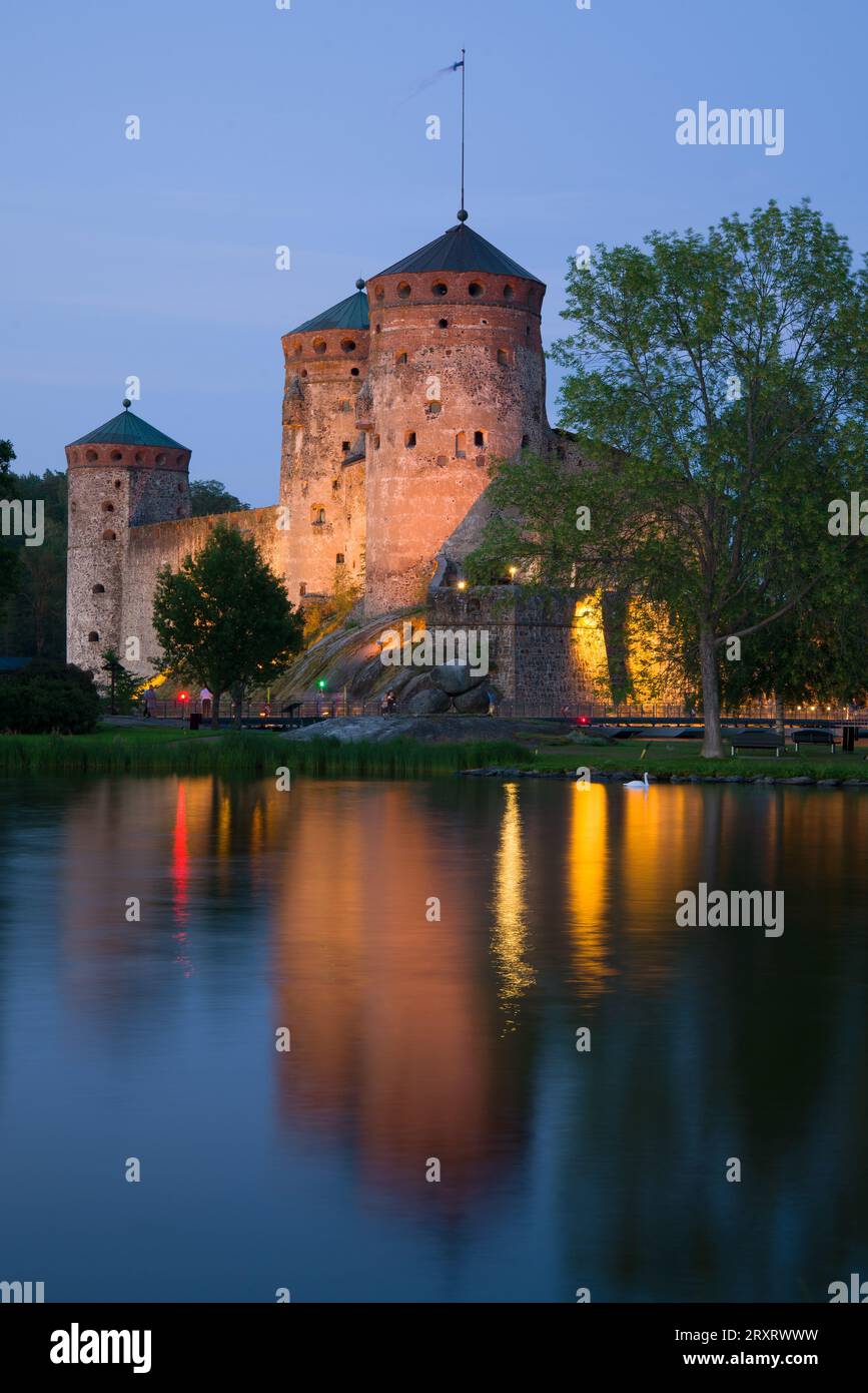 La fortezza medievale di Olavinlinna nell'illuminazione notturna del crepuscolo di luglio. Savonlinna, Finlandia Foto Stock