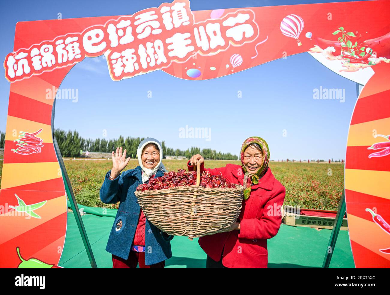 (230927) -- ORDOS, 27 settembre 2023 (Xinhua) -- due contadini posano per una foto di gruppo durante un festival del raccolto nella città di Balagong di Hangjin Banner, regione autonoma della Mongolia interna della Cina settentrionale, 26 settembre 2023. Martedì si è tenuta qui la festa della raccolta del peperoncino, con spettacoli culturali, promozione delle specialità agricole e concorsi di raccolta del peperoncino e di alimentazione del peperoncino. (Xinhua/Peng Yuan) Foto Stock