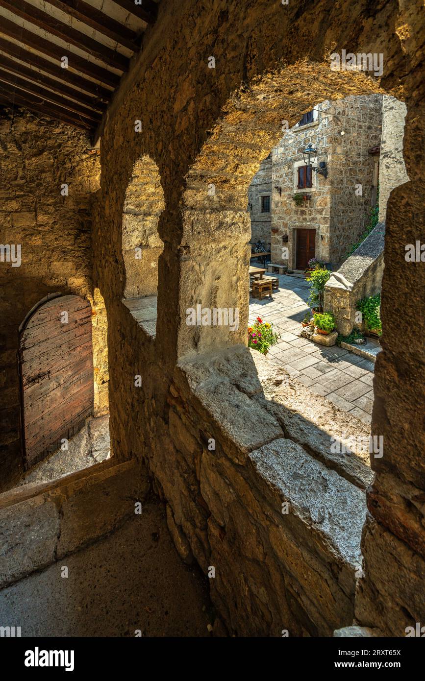 Vista dei vicoli della città di Castel Trosino dagli archi dell'ingresso coperto della casa della regina. Castel Trosino, Marche Foto Stock