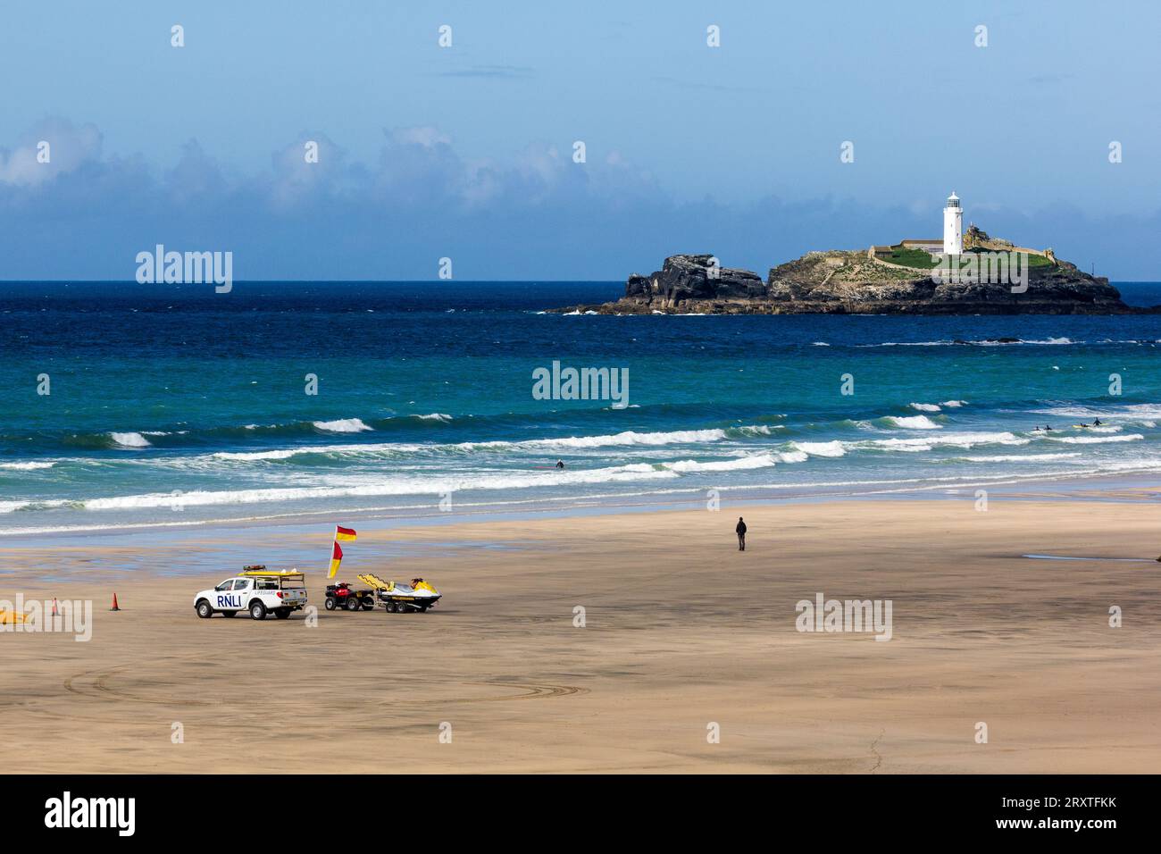 Le guardie del corpo osservano le basse maree, Godrevy Sands, Godrevy Island e il faro con i surfisti che si godono l'Atlantic Surf, Nr. Hayle, Cornovaglia, Regno Unito. Foto Stock