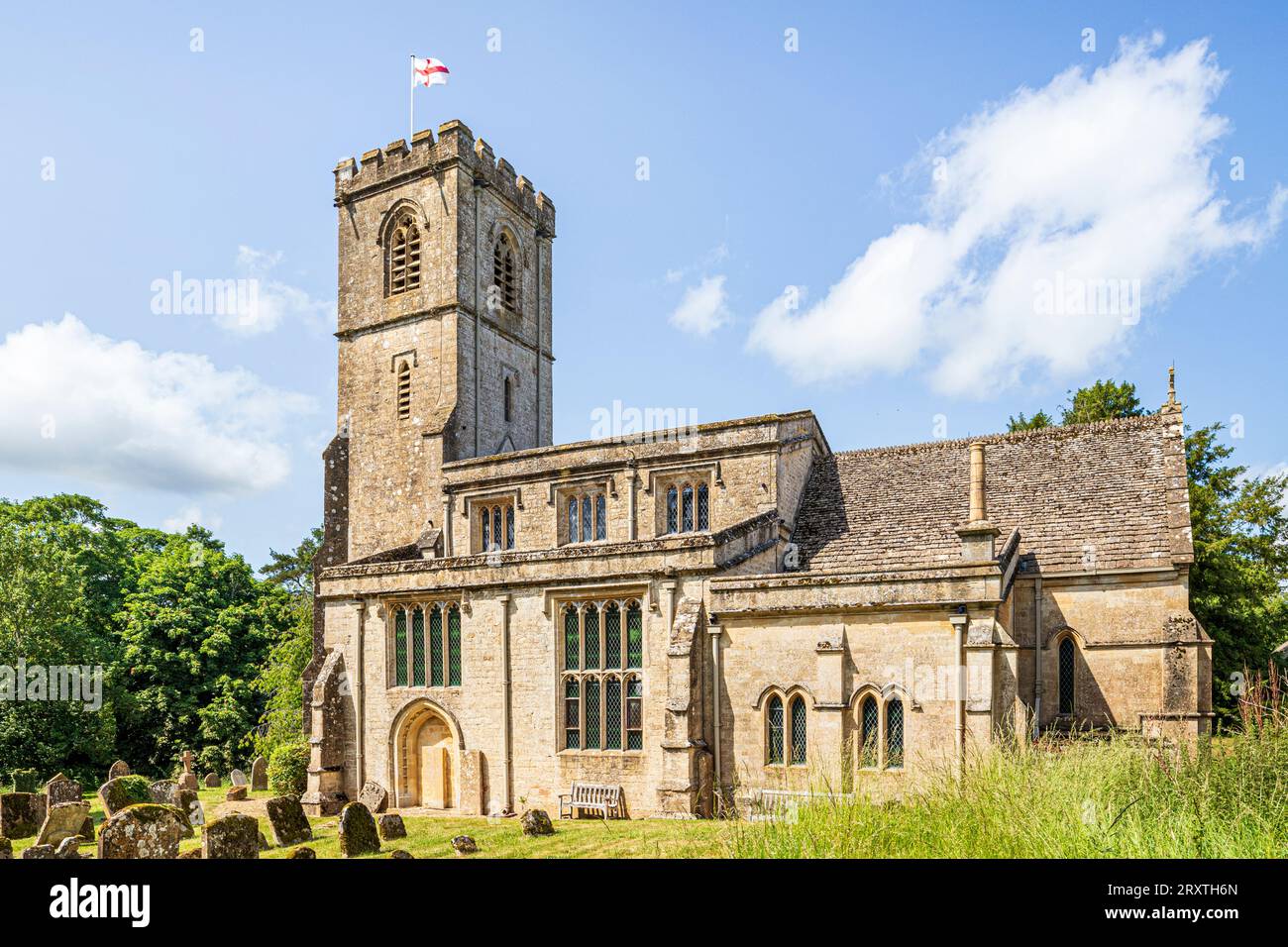 La bandiera di San Giorgio sorvola la chiesa di San Giovanni Evangelista del XIV secolo nel villaggio Cotswold di Taynton, Oxfordshire, Inghilterra, Regno Unito Foto Stock