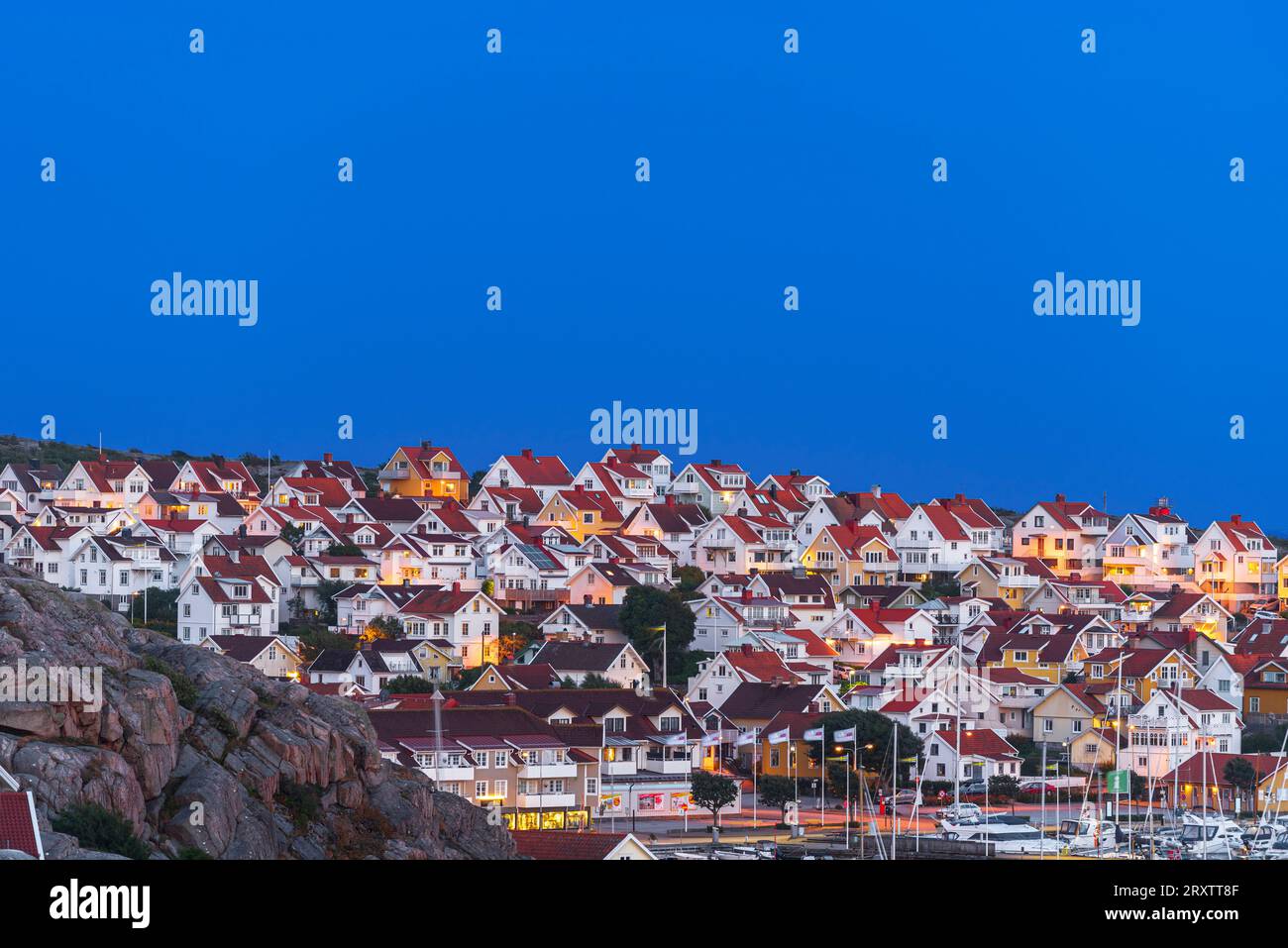 Villaggio illuminato tradizionale di Kungshamn al tramonto, Bohuslan, Vastra Gotaland, Svezia occidentale, Svezia, Scandinavia, Europa Foto Stock