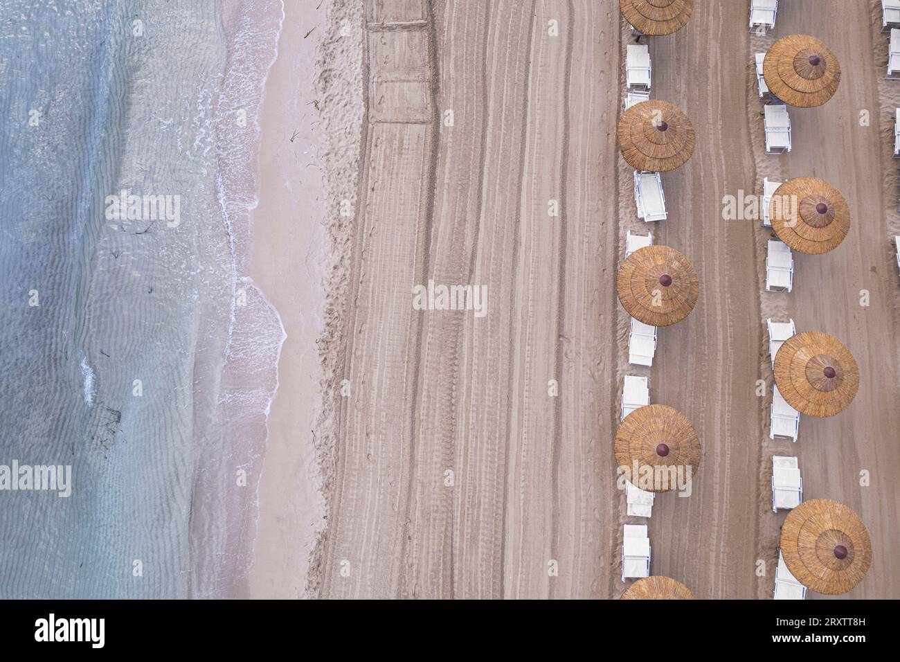 Vista droni degli ombrelloni da spiaggia su una spiaggia vuota, Sicilia, Mar Mediterraneo, Italia, Europa Foto Stock