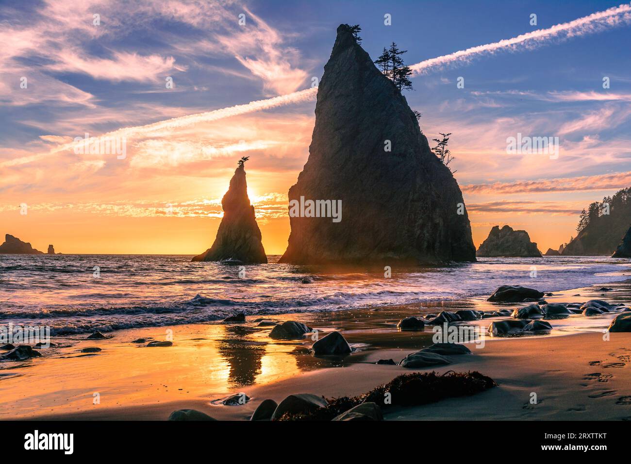 Tramonto dorato sulla spiaggia di Rialto con sole dietro le iconiche formazioni rocciose, Stato di Washington, Stati Uniti d'America, Nord America Foto Stock