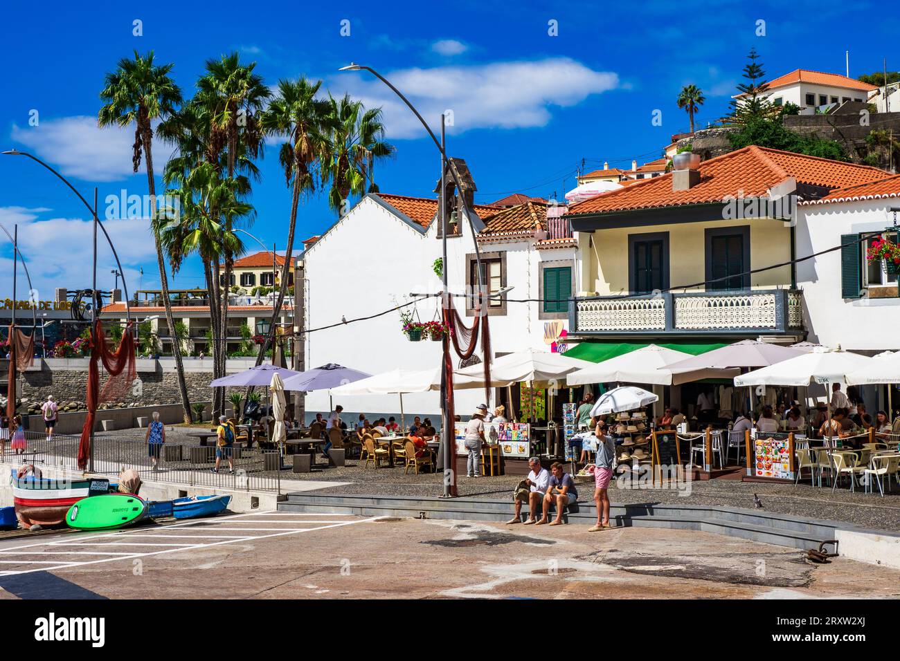 Vista panoramica del piccolo villaggio di pescatori di Câmara de Lobos a Madeira, Portogallo, dove i turisti si godono la vita del porto sul lungomare Foto Stock