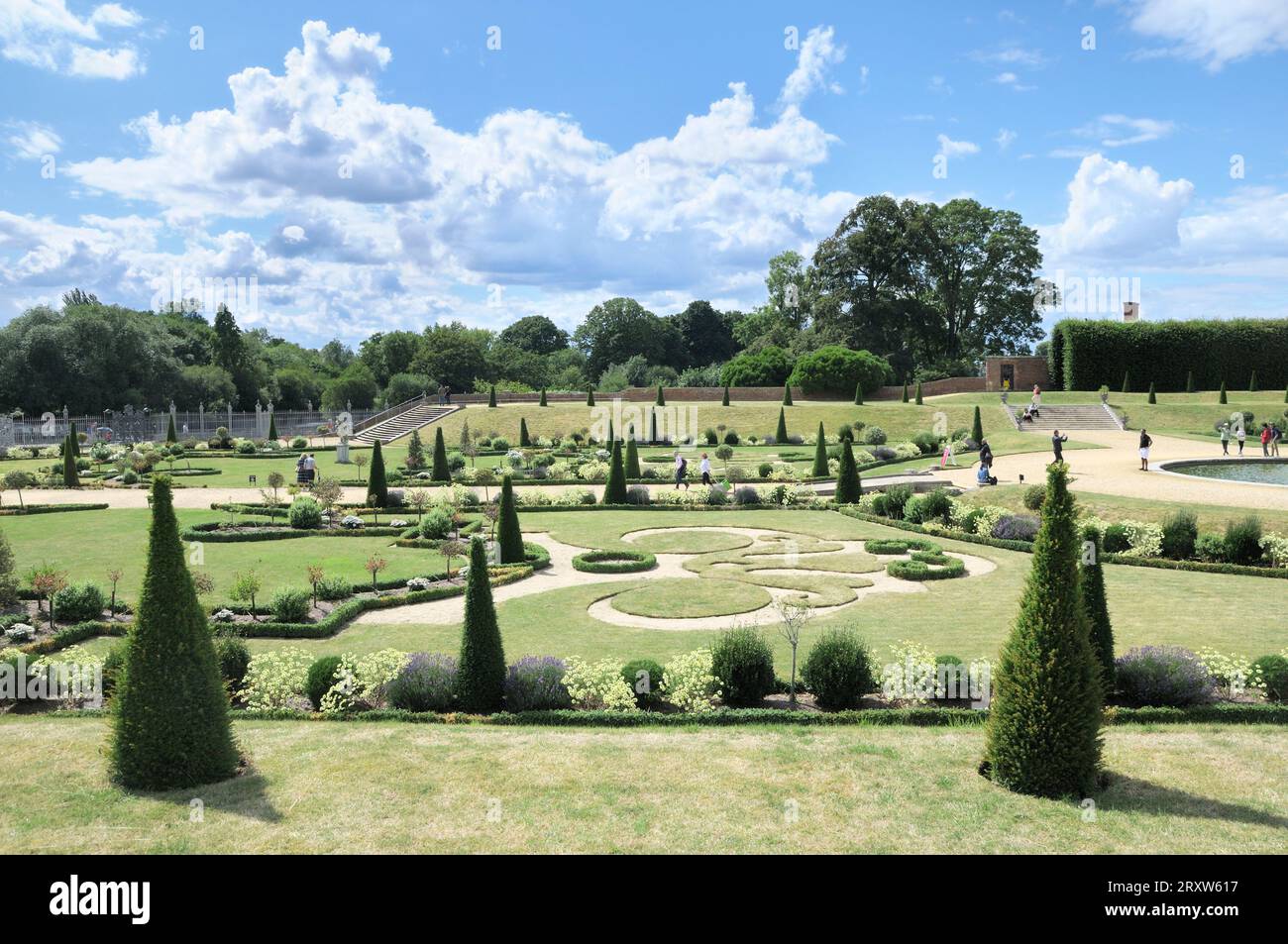 Il Privy Garden all'Hampton Court Palace con parterres su sentiero di ghiaia, scultura in erba gazon coupé e topiario ritagliato. Giardini in stile barocco inglese. Foto Stock
