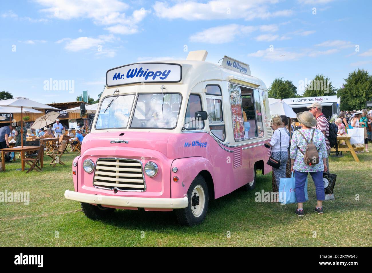 La gente fa la fila ad un furgone rosa vintage Mr Whippy gelato in estate al RHS Hampton Court Palace Garden Festival, precedentemente Hampton Court Flower Show, Regno Unito Foto Stock