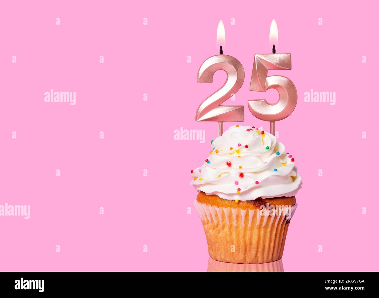 Torta di compleanno con candela numero 25 - su sfondo rosa. Foto Stock