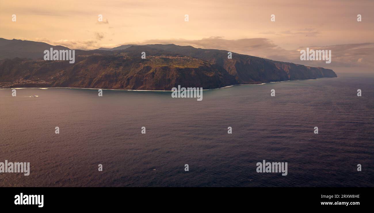 Fantastica e panoramica vista da cartolina della verde e ripida costa rocciosa di Madeira vicino a Porto Moniz, Portogallo, che si innalza maestosamente dal mare Foto Stock