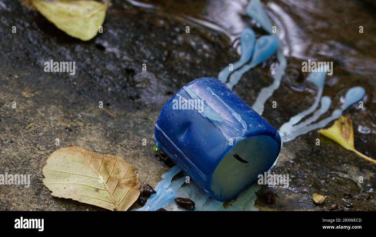 Una candela blu su una roccia in un ruscello di montagna. La cera fluisce nell'acqua. Foto Stock