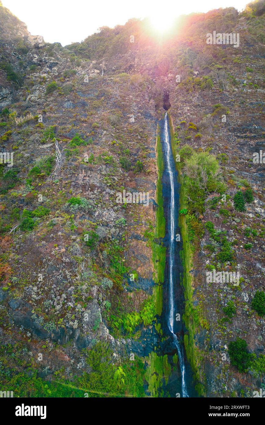 Vista panoramica di una piccola cascata vicino a São Vicente che scende lungo le ripide pendici di Madeira Foto Stock