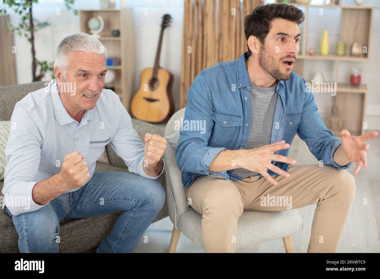 felice famiglia maschile di due generazioni che guarda la tv Foto Stock