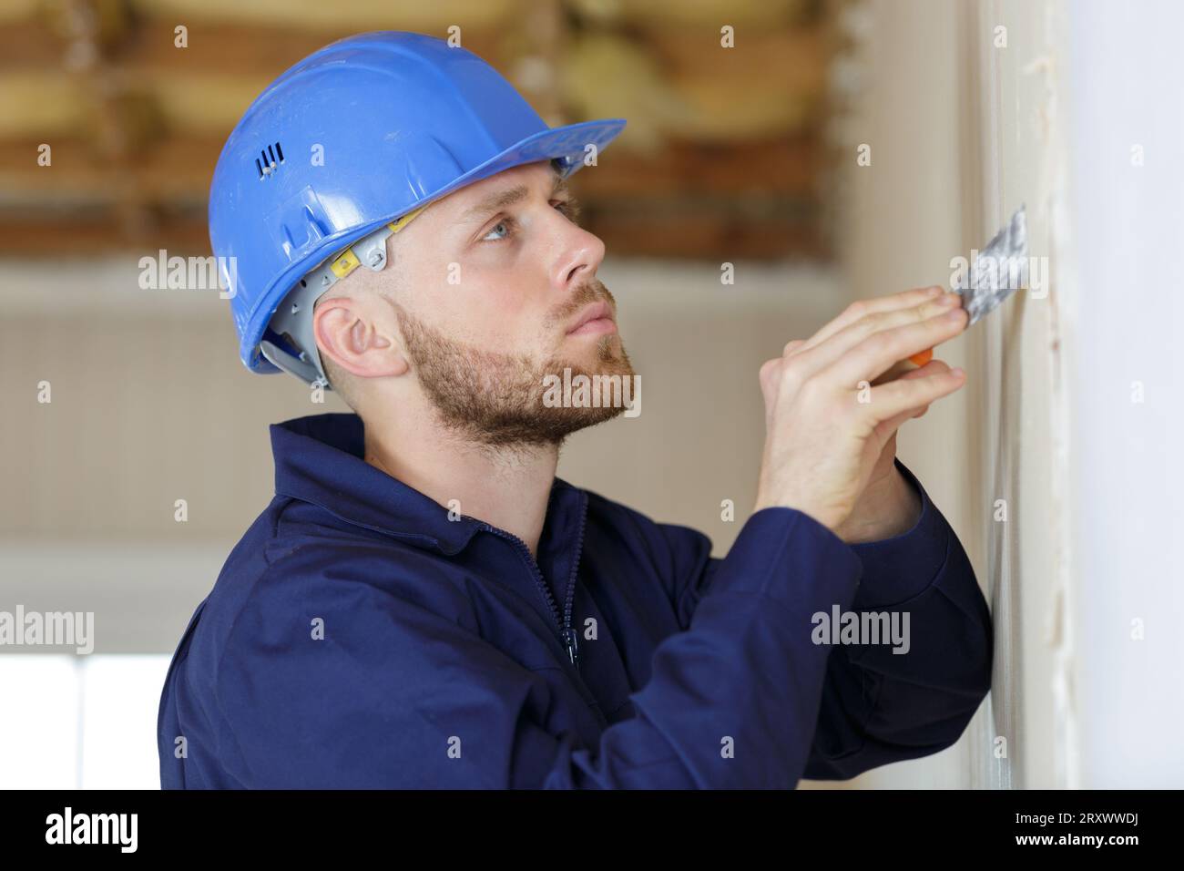 Lavoratore edile con lunga cazzuola intonacatura di una parete Foto Stock