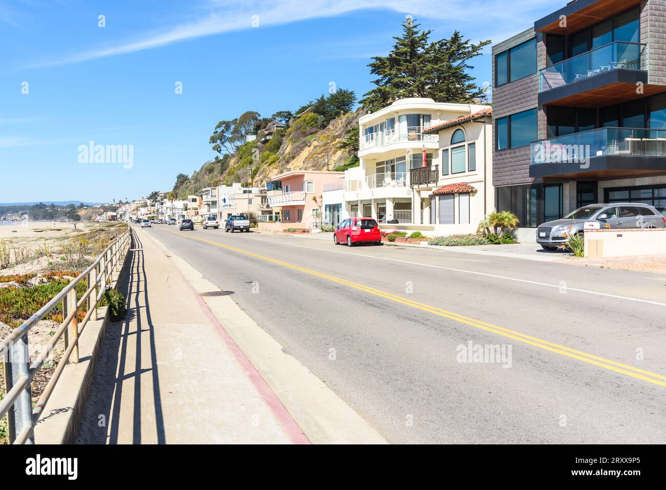 Strada costeggiata da case e appartamenti lungo una spiaggia sabbiosa in una chiara giornata autunnale Foto Stock