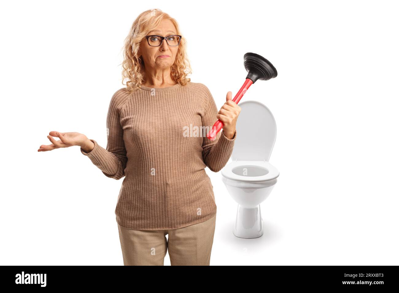 Donna matura confusa che tiene uno stantuffo del gabinetto davanti a un sedile isolato su sfondo bianco Foto Stock