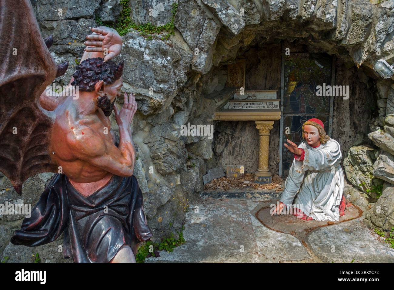 Scultura del diavolo e Sant'Antonio da Padova nella grotta nel villaggio di Crupet, Assesse, provincia di Namur, Ardenne belghe, Vallonia, Belgio Foto Stock