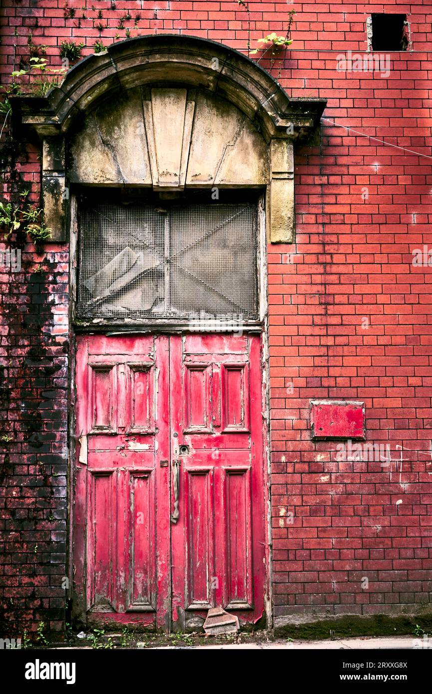 Vecchie porte rosse. Fabbrica abbandonata a Heywood, Manchester. Vecchia architettura. Foto Stock