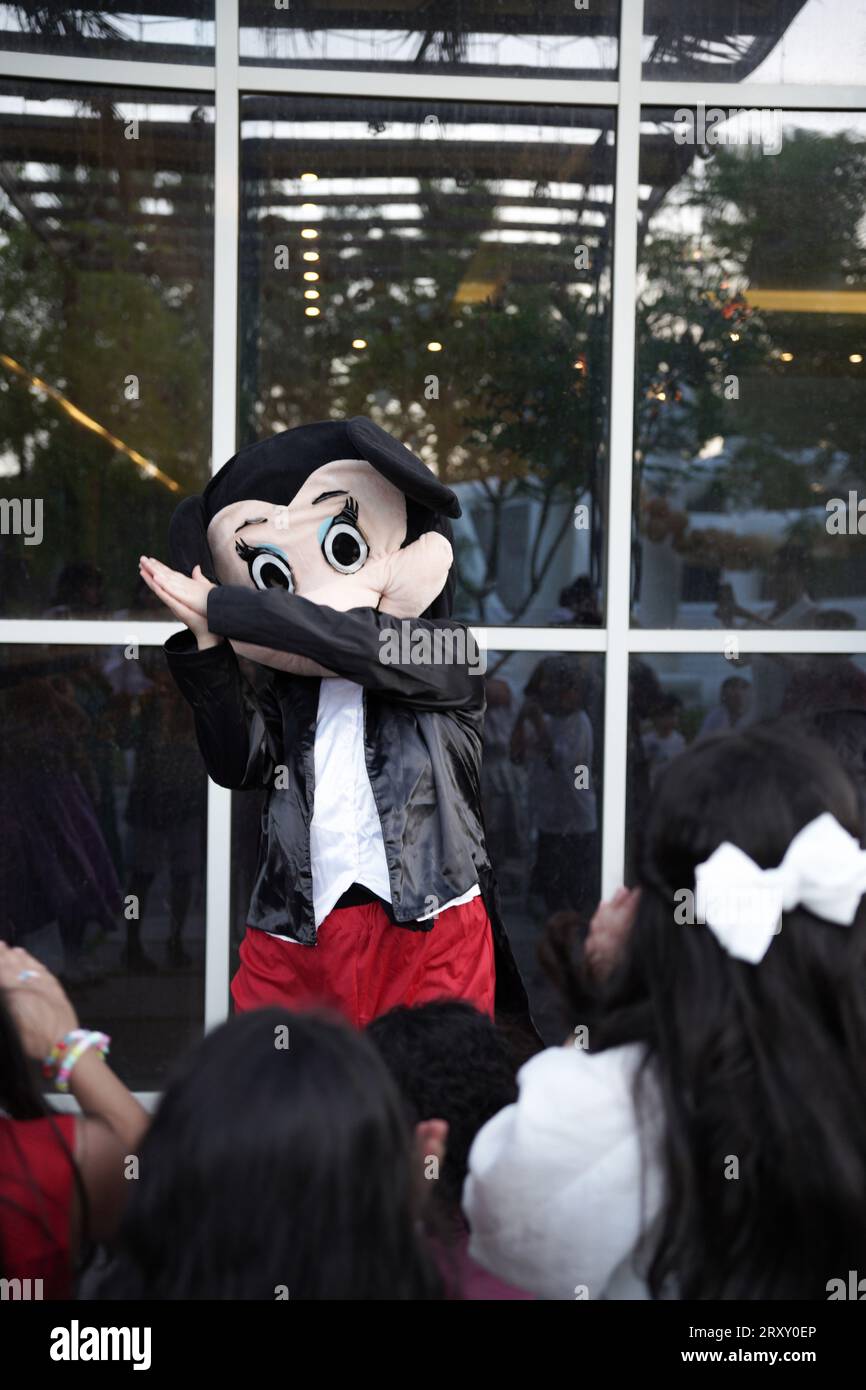 Clown o personaggio che gioca con i bambini. festa di compleanno all'aperto per bambini. Bambini che giocano con il clown. bambini che giocano con la persona che indossa micky mouse Foto Stock