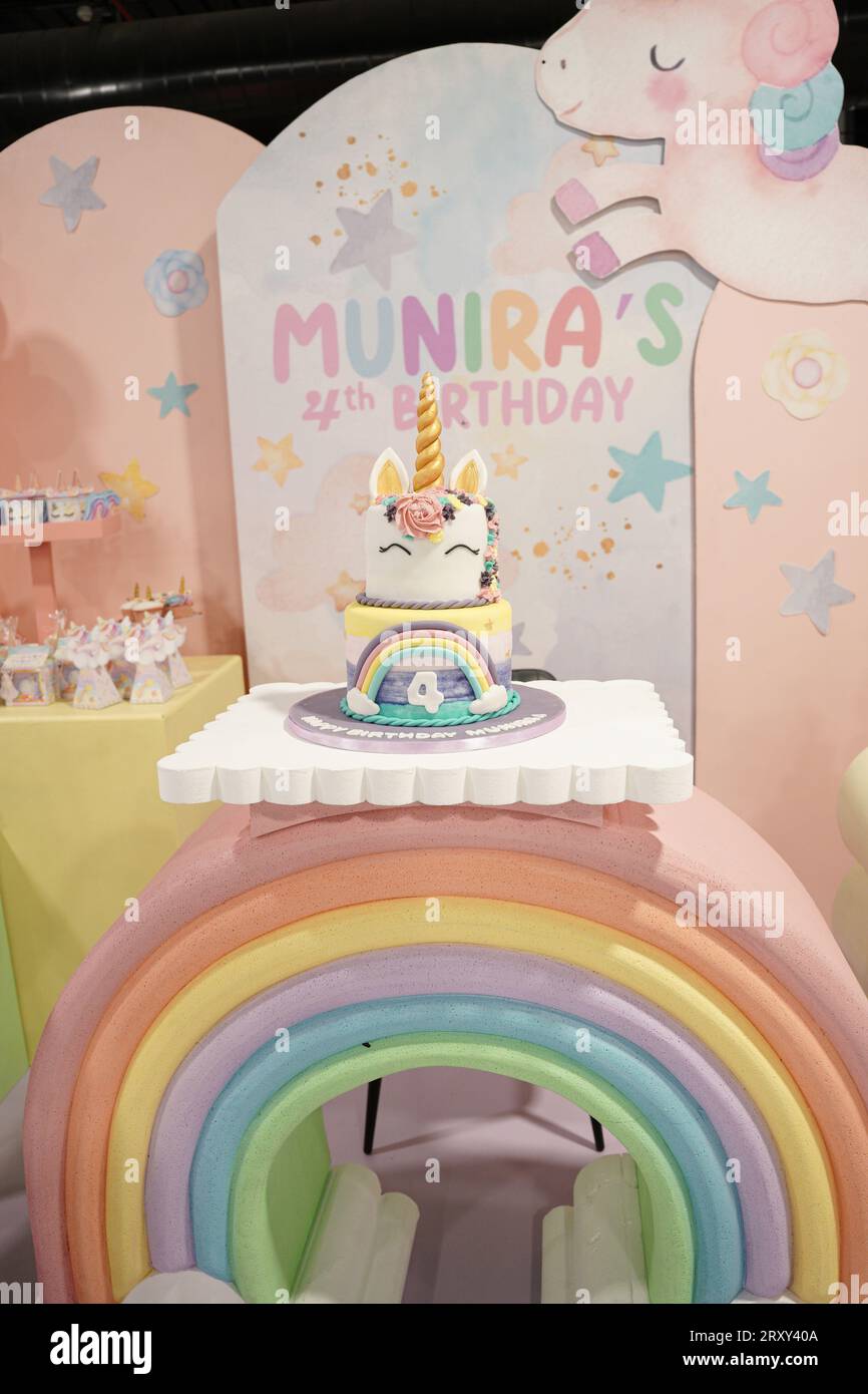 Torta di compleanno unicorno decorata con arcobaleno e corno d'oro, palloncini e spuntini. Torta Unicorn Birthday Party, quarto compleanno di Sara Foto Stock