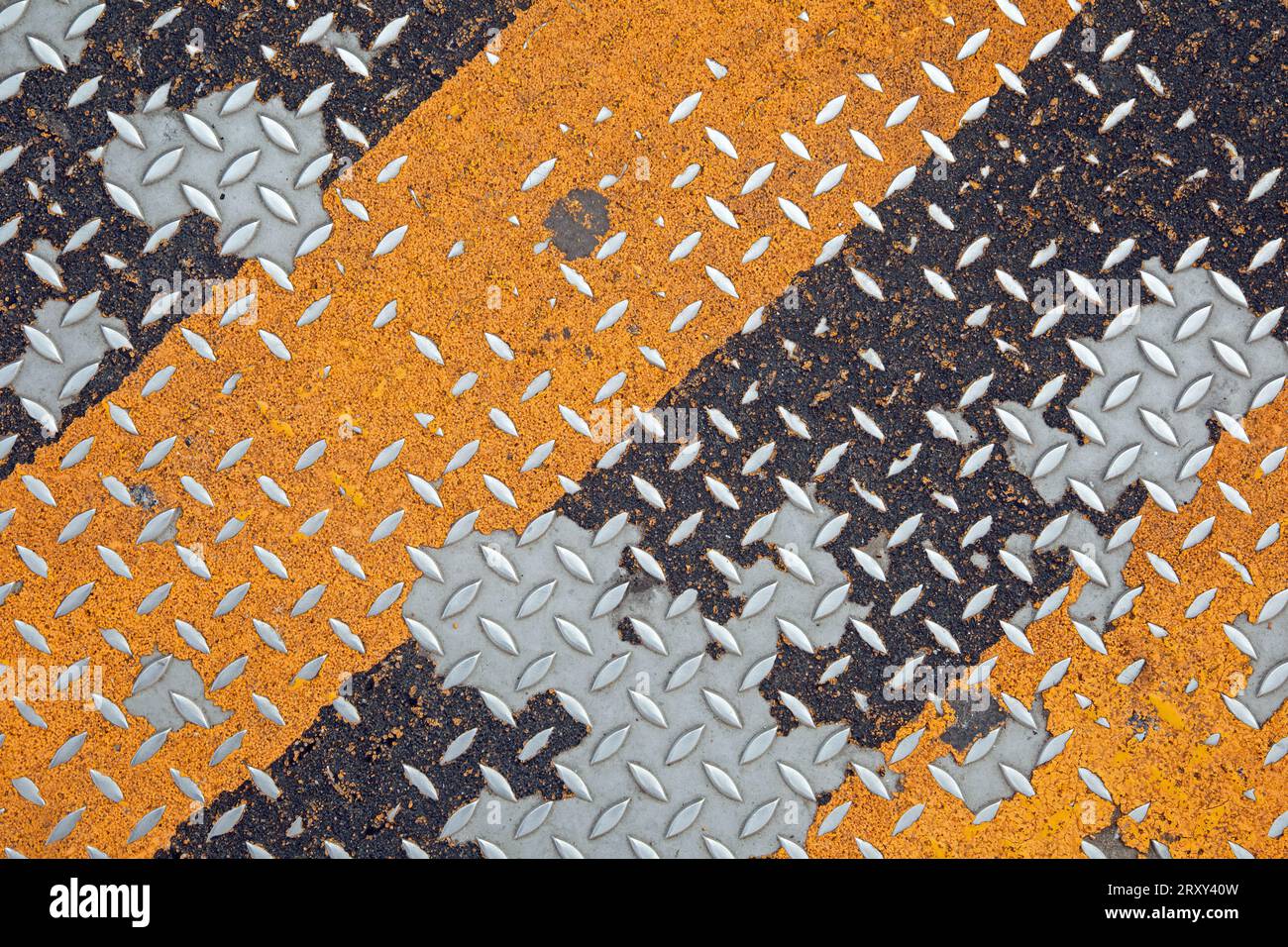 Strisce diagonali gialle e nere su una piastra di acciaio pied de poule Foto Stock