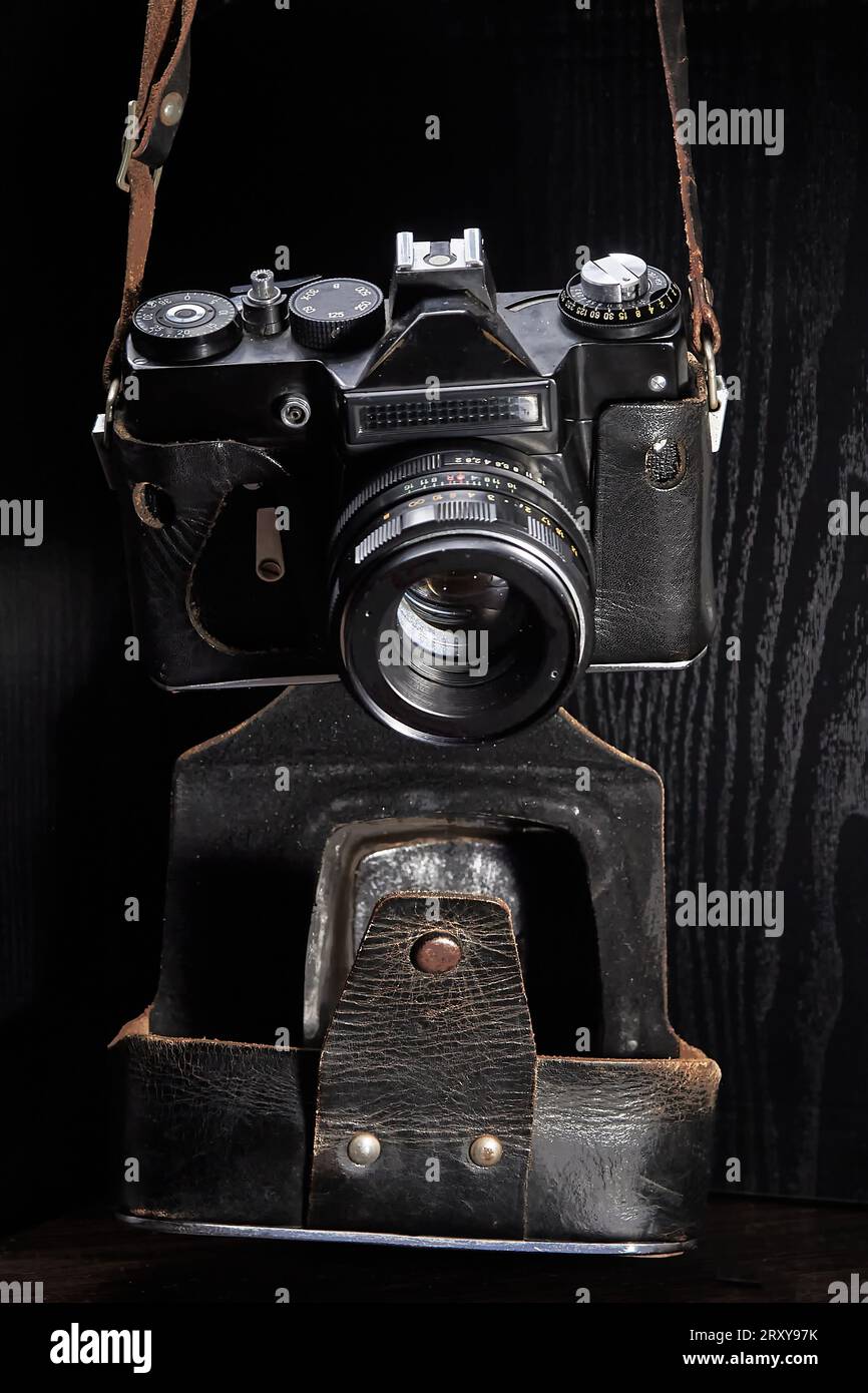 Una vecchia fotocamera reflex con telemetro a film in una custodia usurata Foto Stock