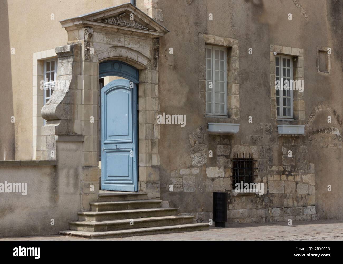 Vecchia porta in pietra color crema su alcuni gradini Foto Stock