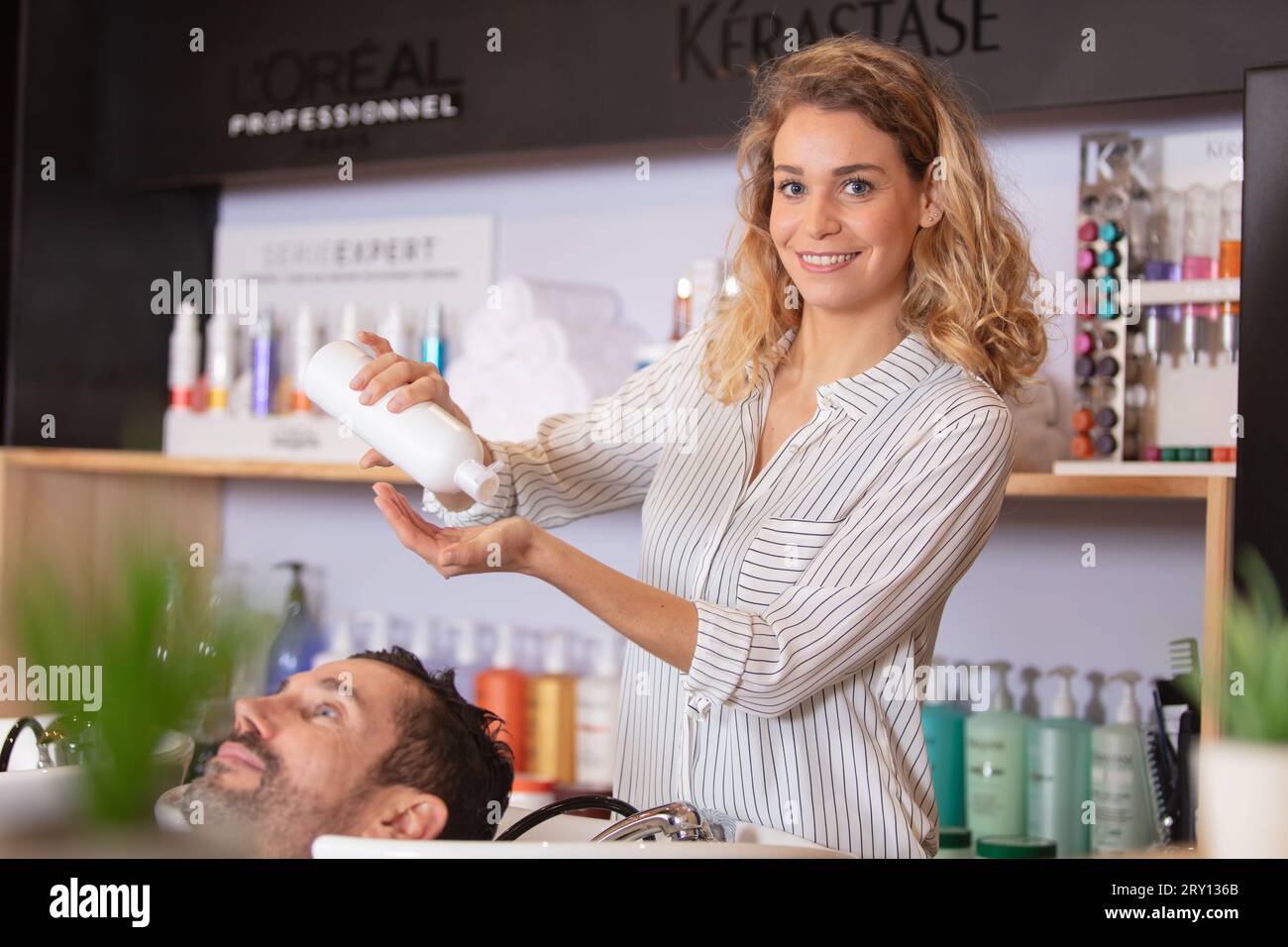 parrucchiere che lavora sul taglio di capelli per un cliente felice Foto Stock