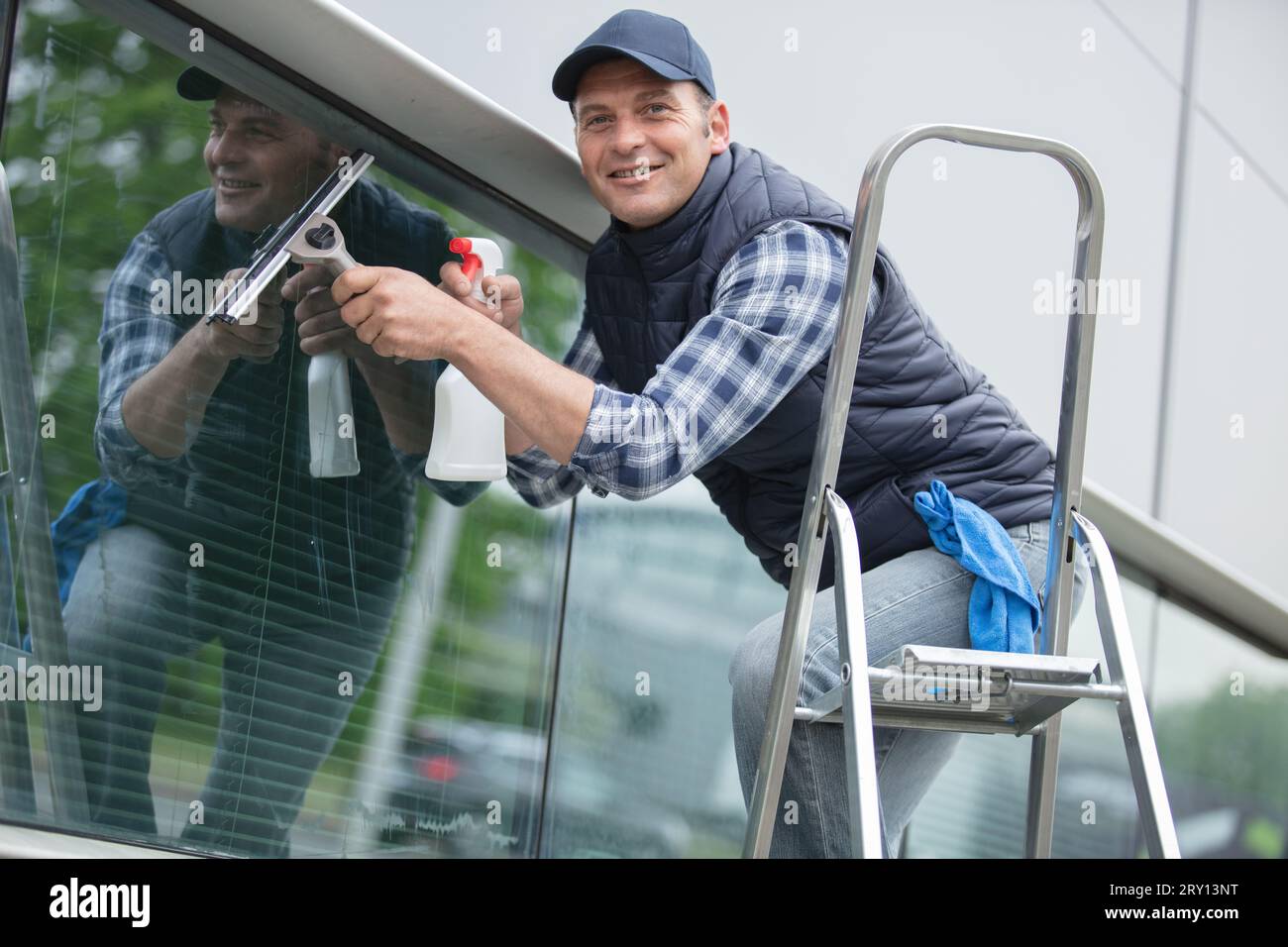 un uomo felice che pulisce la finestra Foto Stock