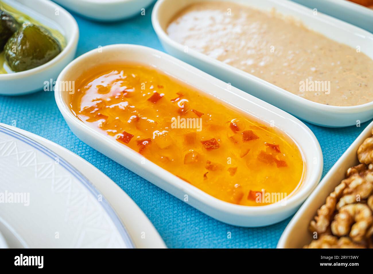 Marmellata d'arancia in una ciotola di porcellana bianca sul tavolo della colazione Foto Stock