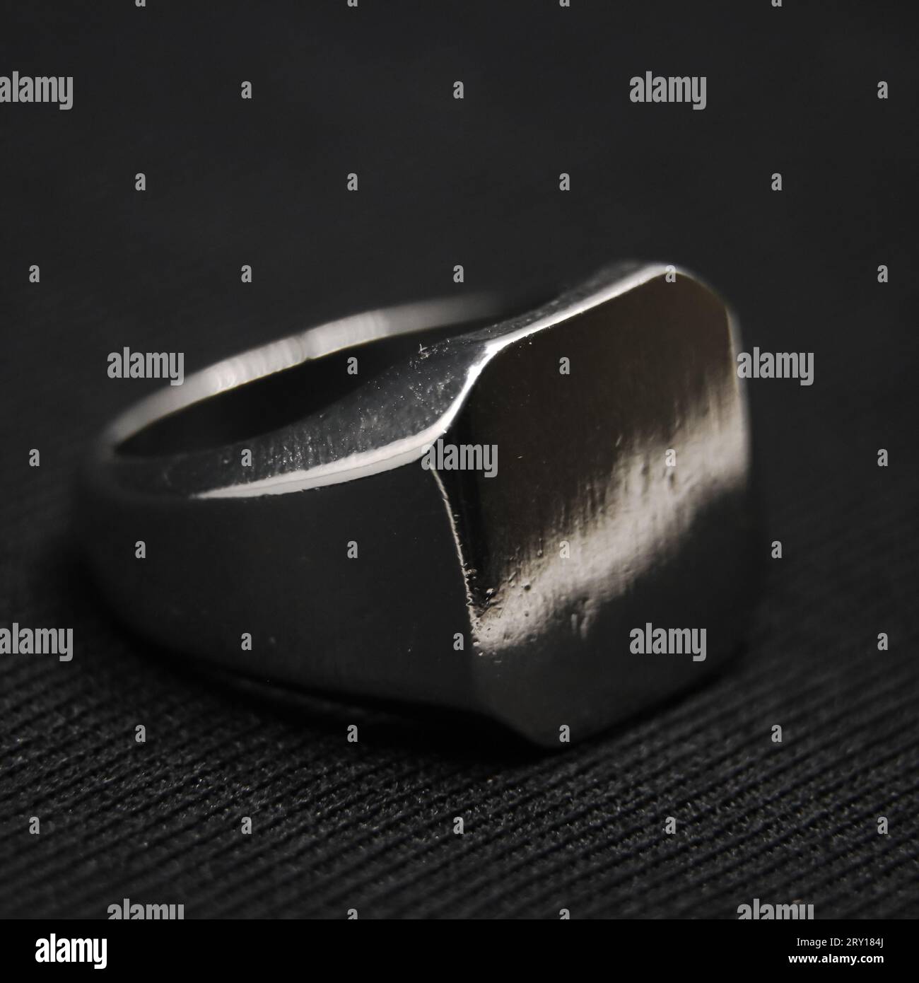 classico anello in platino metallico antico con taglio quadrato isolato su sfondo nero in primo piano Foto Stock