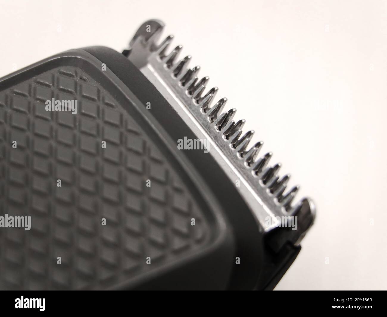 macro shot di primo piano dei denti del regolacapelli o della lama del rifinitore utilizzati per la rasatura su uno sfondo bianco Foto Stock