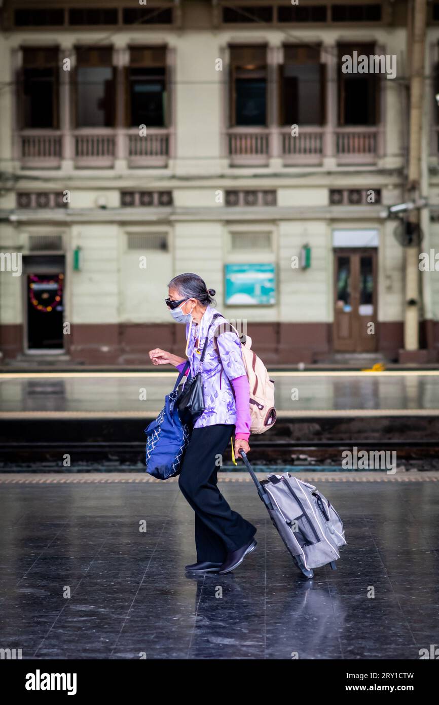 Una vecchia signora thailandese sbarca sul binario alla stazione ferroviaria di Hua Lamphong Pathum Wan, Bangkok Thailandia. Foto Stock