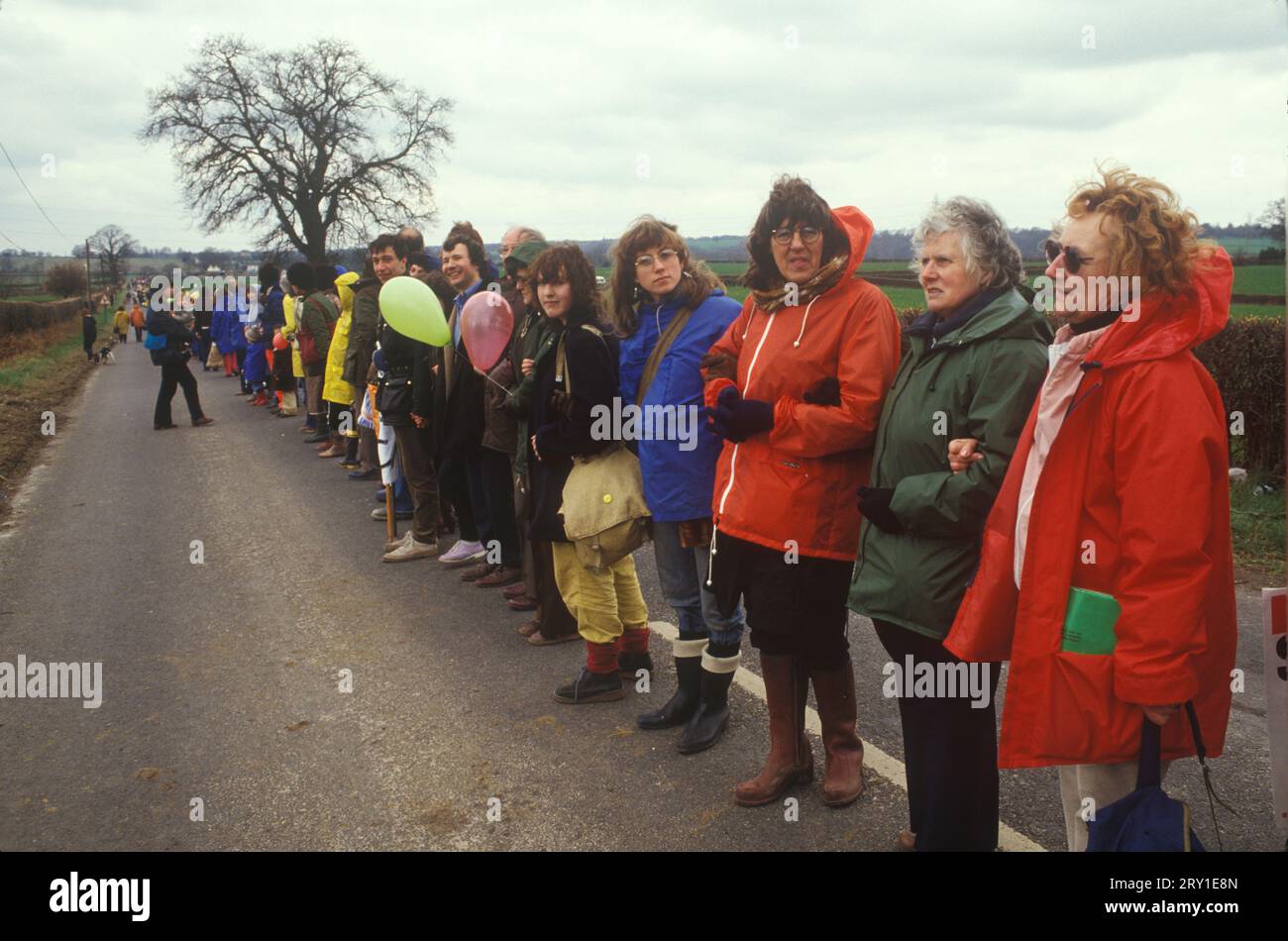 Da Aldermaston a Greenham Common Easter 1983. I dimostranti di pace formarono una catena umana che si estendeva per 22 miglia. Hanno tracciato una strada lungo quella che i manifestanti chiamano "Nuclear Valley" nel Berkshire. La catena è iniziata presso la base aerea americana di Greenham Common, ha superato il centro di ricerca nucleare di Aldermaston e si è conclusa presso la fabbrica di ordigni di Burghfield. 1980S UK HOMER SYKES Foto Stock
